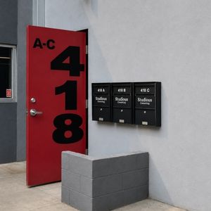 Red door with address 418 and three black mailboxes